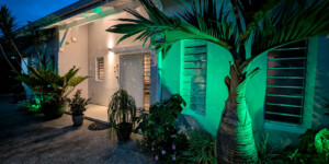 Entrée de la Villa Corail éclairée de nuit dans le jardin tropical